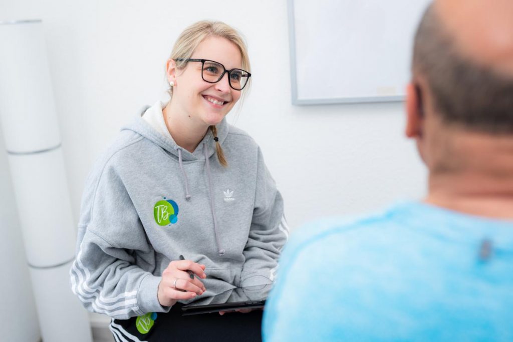 Lisa Brall mit einem Patienten bei der Physiotherapie