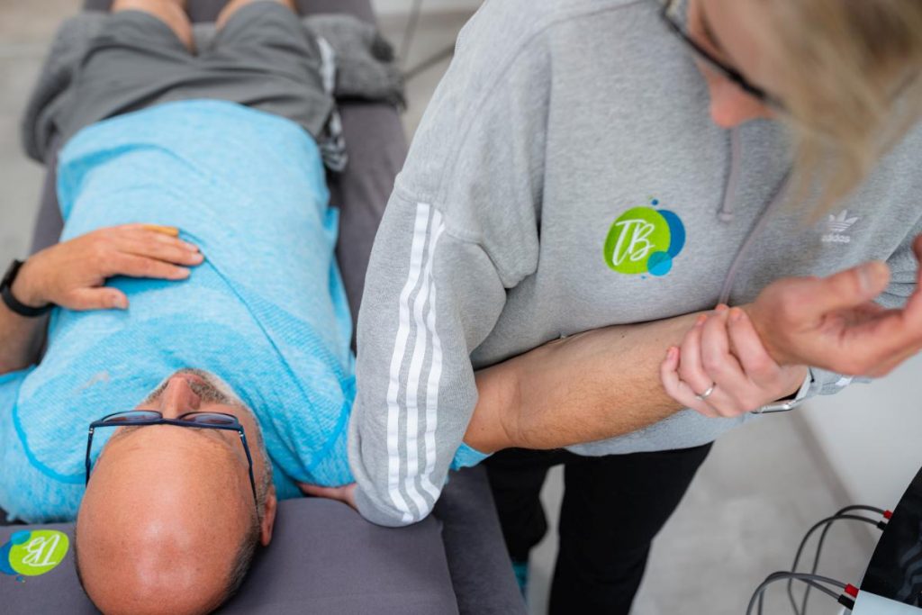 Lisa Brall mit einem Patienten bei der Physiotherapie