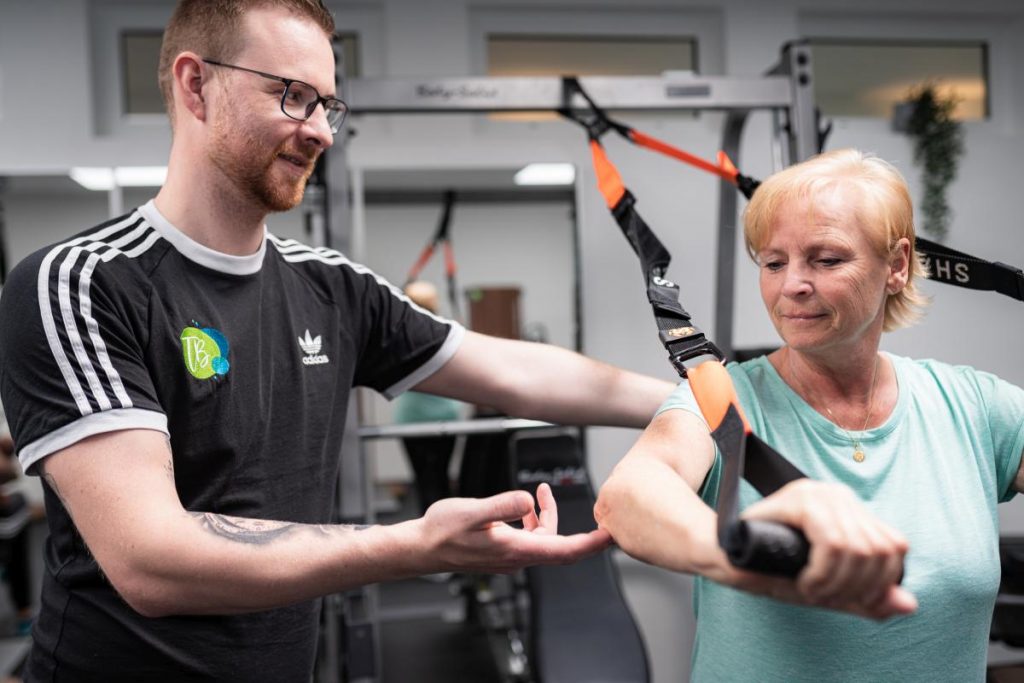 Tobias Brall erklärt einer Patientin die sportliche Übung